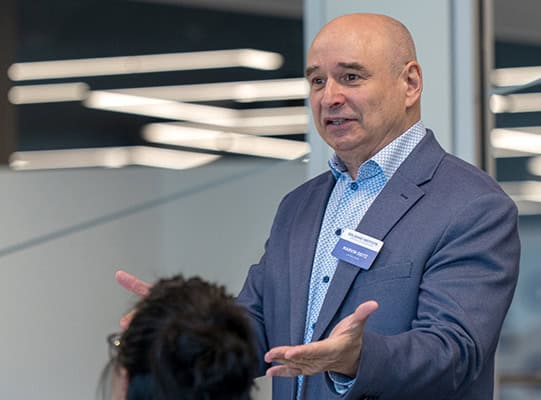 Dr. Marvin Deitz gestures with his hands while speaking to a class.